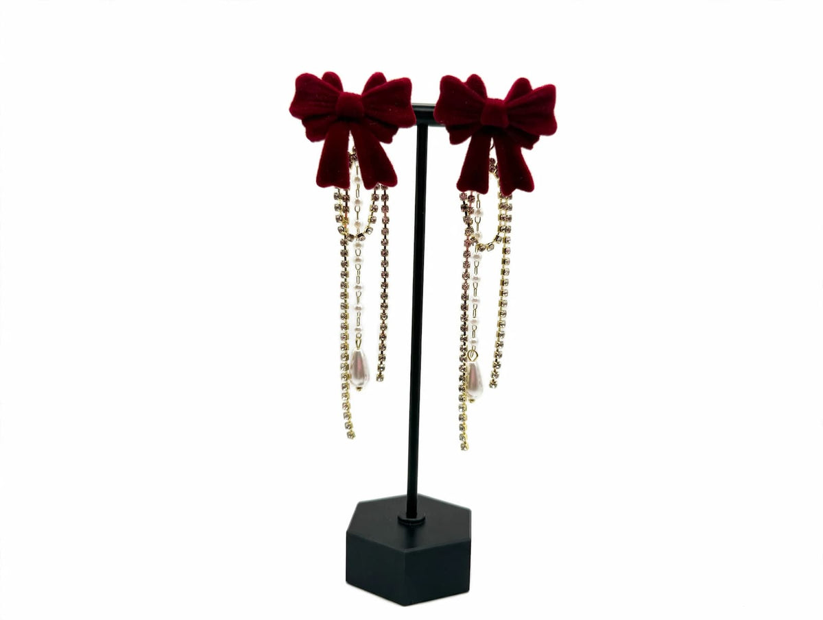 Red flocked bow earrings shown with cascading rhinestone-and-pearl decorative backs attached