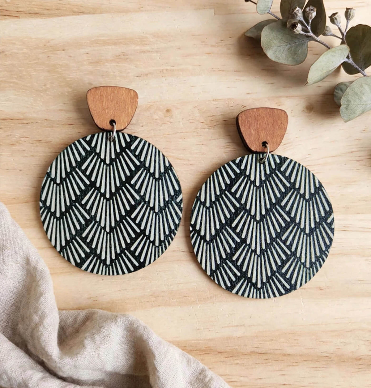 Black and white fan-pattern round wooden dangle earrings with brown wood tops