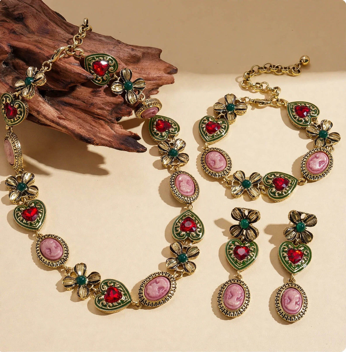 Vintage-inspired cameo jewelry set with red heart rhinestones, green floral details, and gold-colored trim.