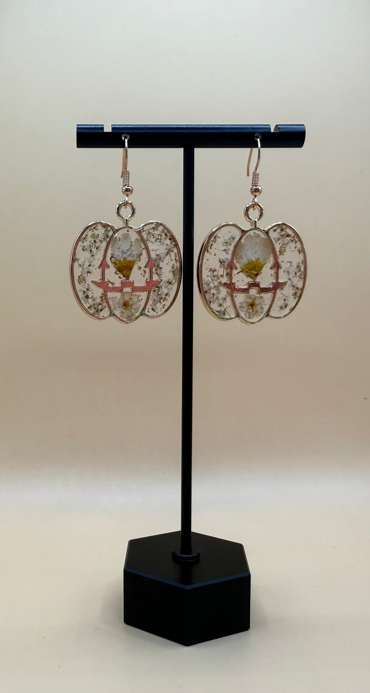 Halloween Pressed Flower Pumpkin Earrings on display stand