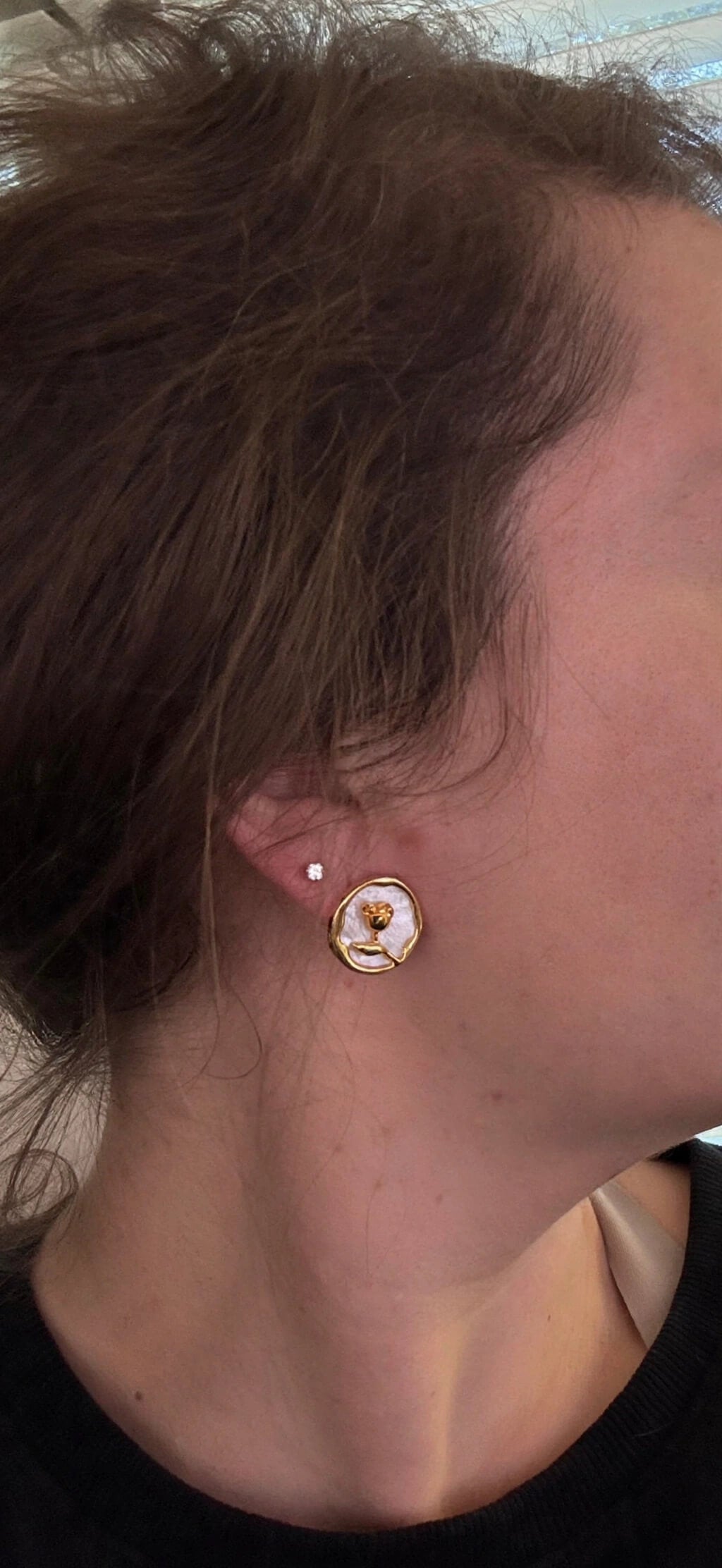 Model wearing a gold and white rose floral coin clip-on earring