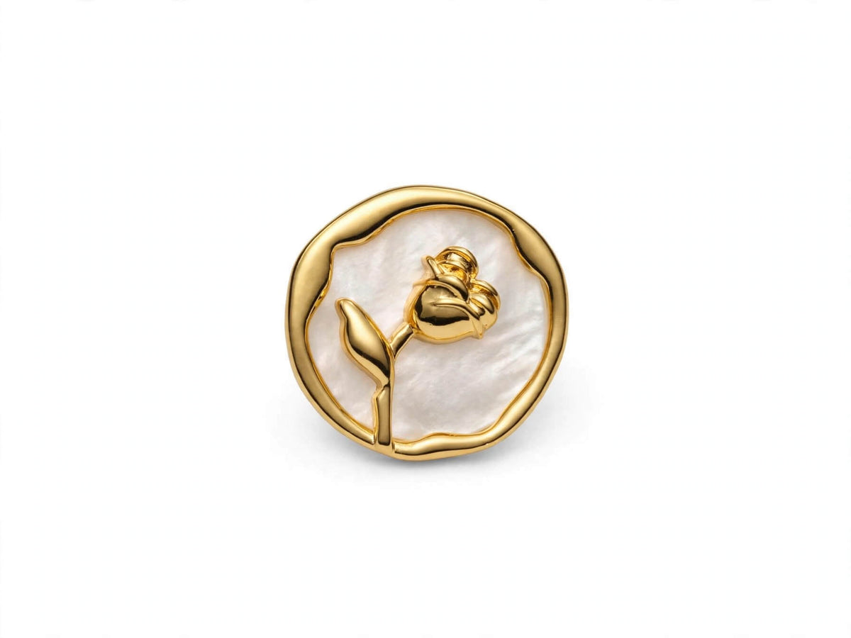 Gold-colored rose and leaf design on a white round coin earring with an irregular border