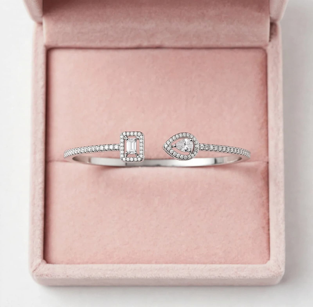 Silver-tone teardrop and rectangle CZ cuff bracelet on a white jewelry stand