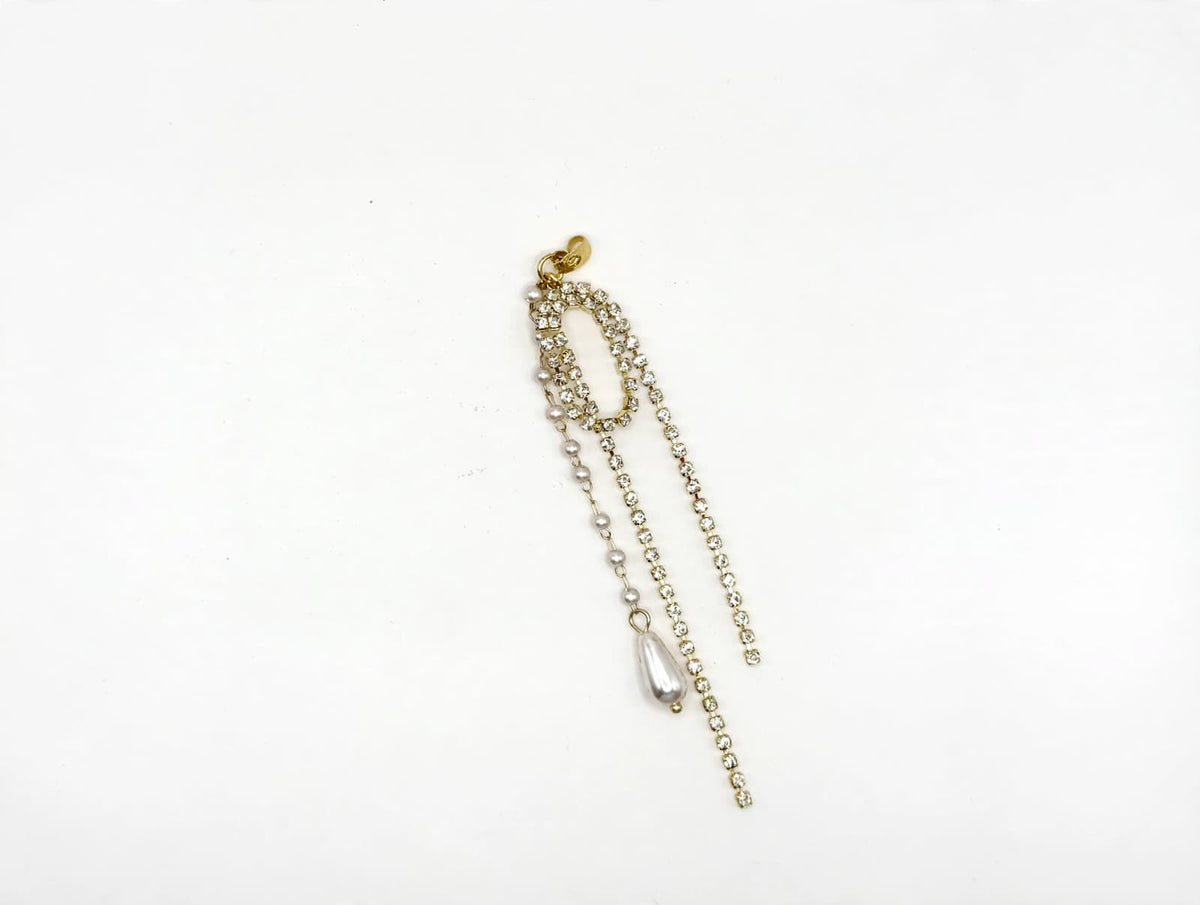 Close-up of a removable rhinestone-and-pearl decorative earring back with gold-tone detailing