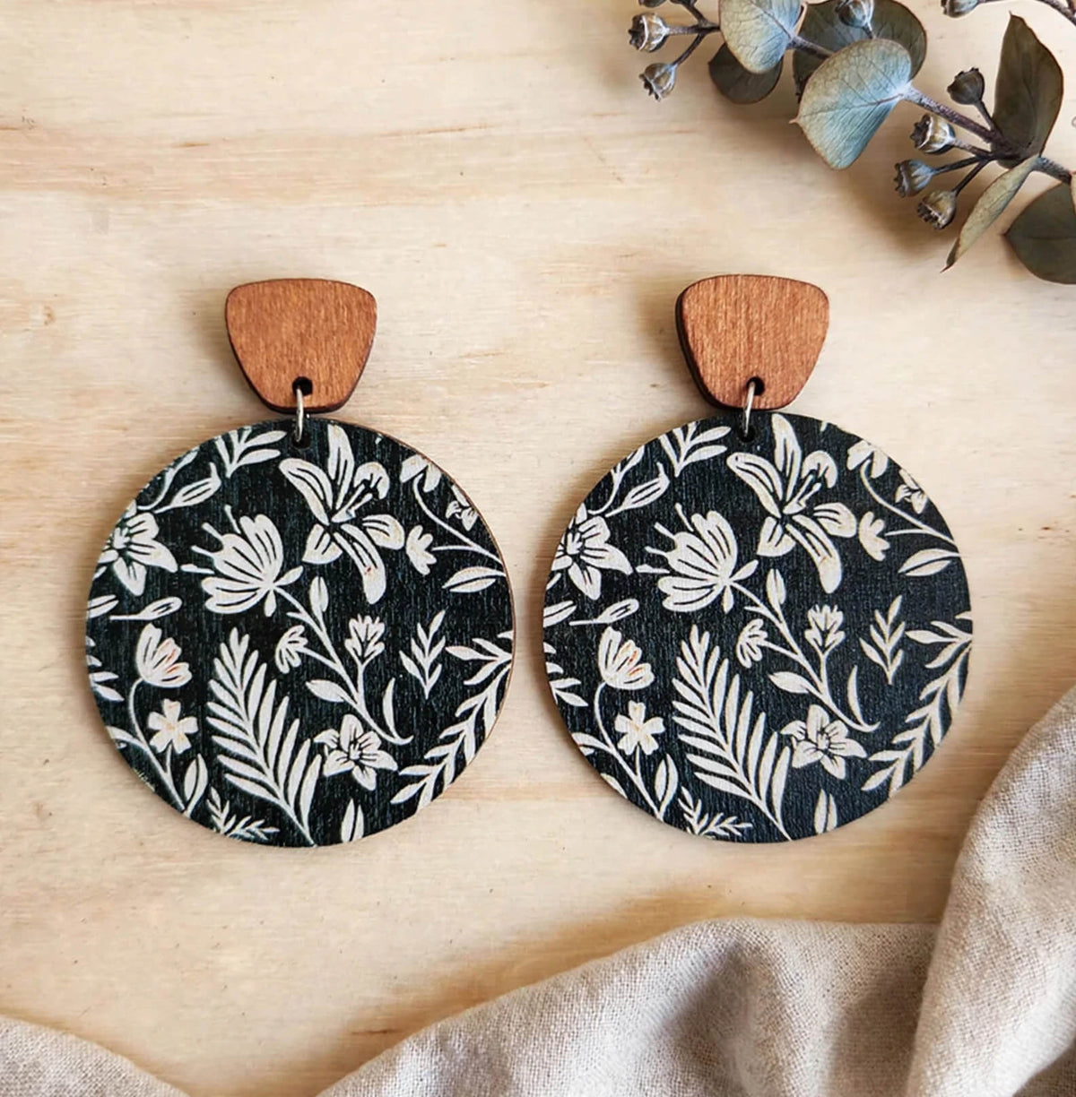 Black and white floral round wooden dangle earrings with brown wood tops