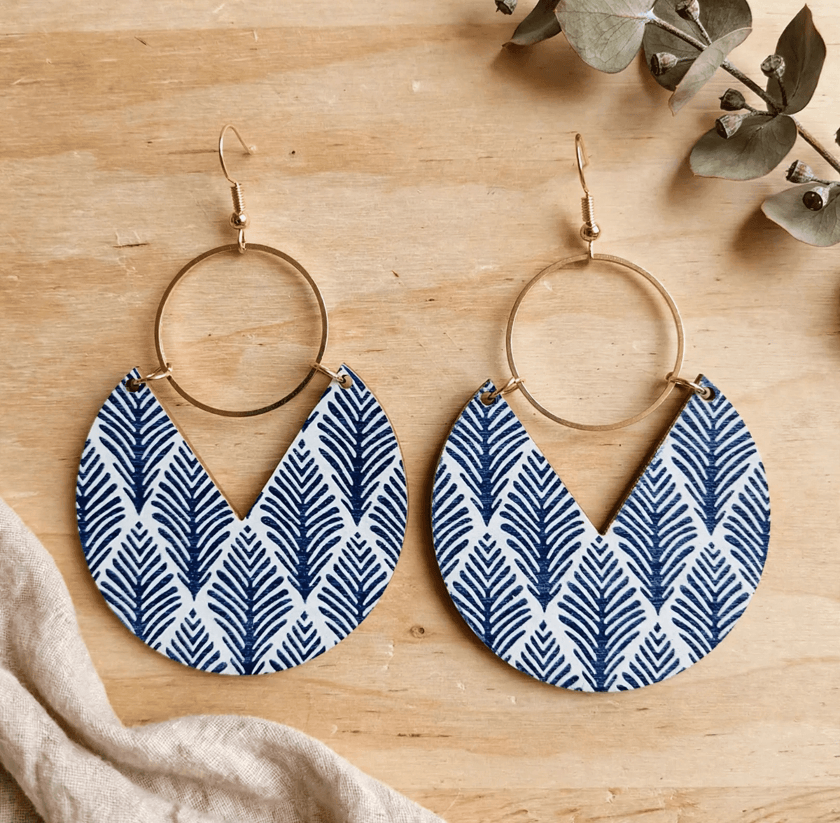 Blue leaf-patterned wooden drop earrings with open gold-tone rings