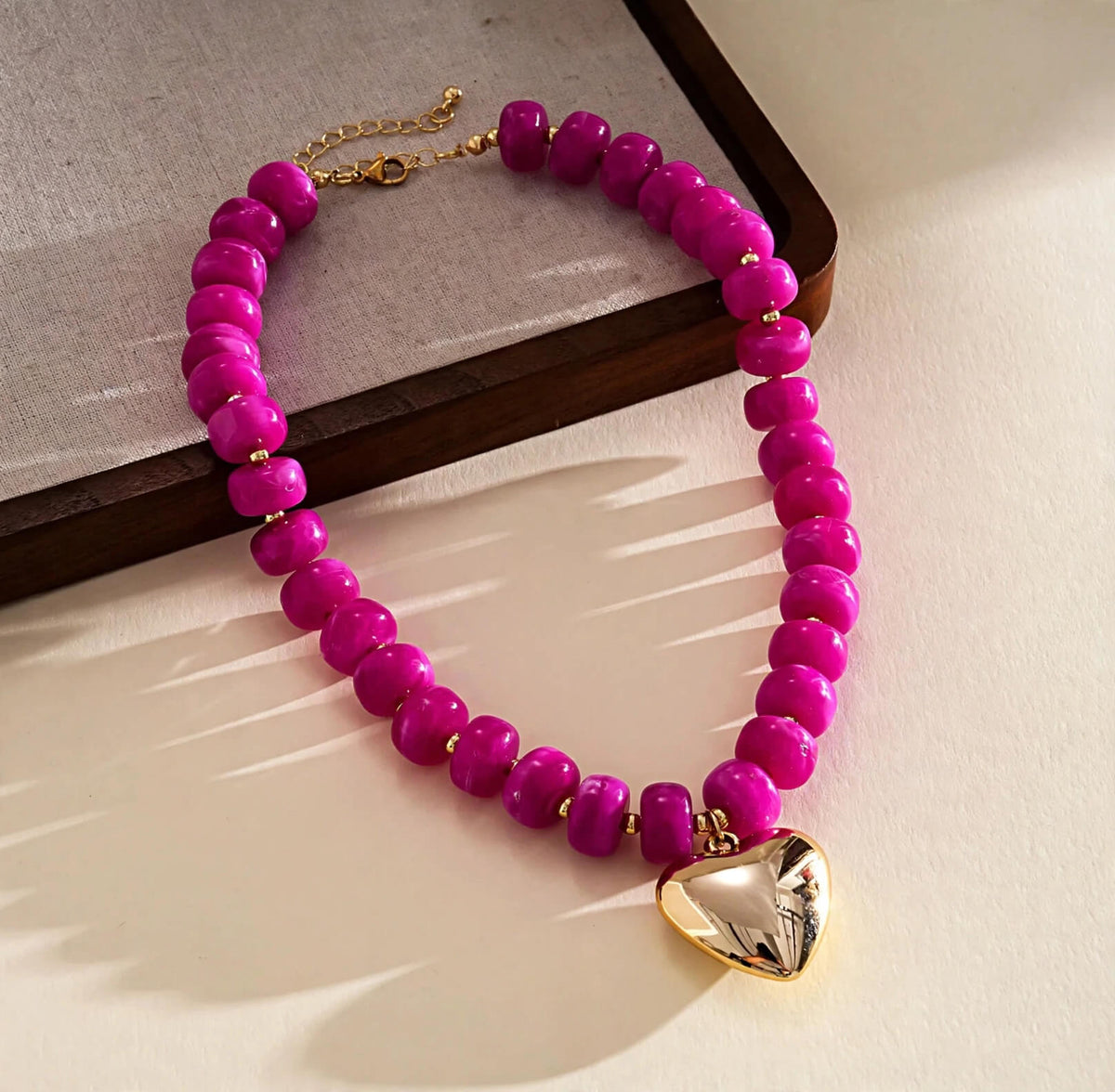Pink chunky beaded necklace with gold-tone puffy heart pendant and extender chain