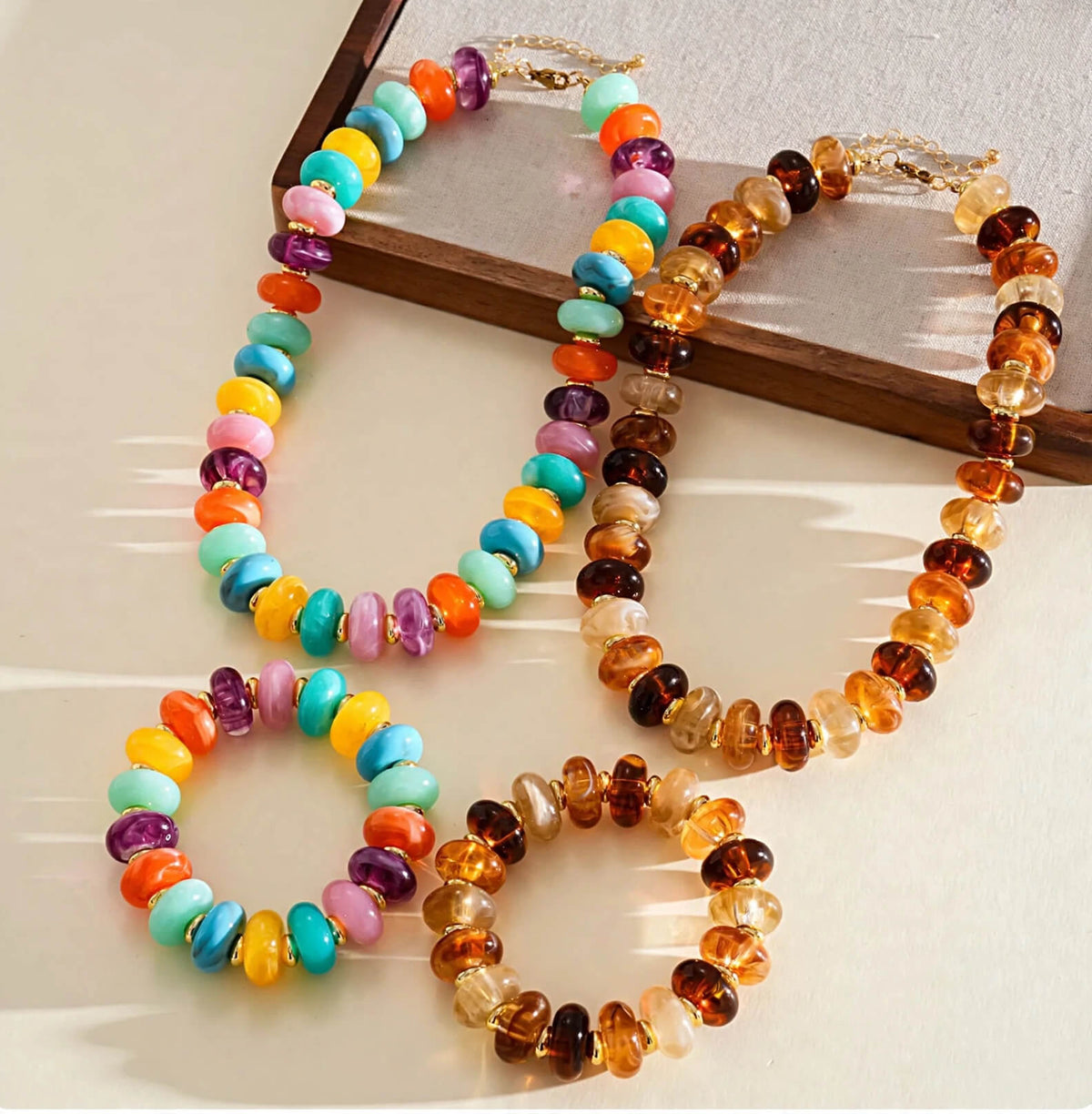 Amber and multicolor acrylic rondelle bead necklace and bracelet sets with gold-tone spacers