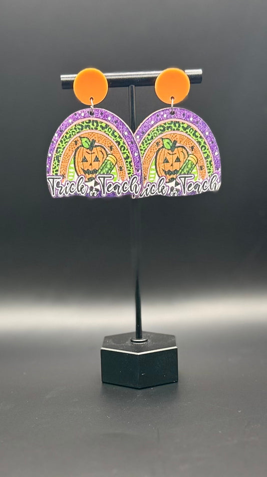 Trick or Teach earrings on display stand — front view